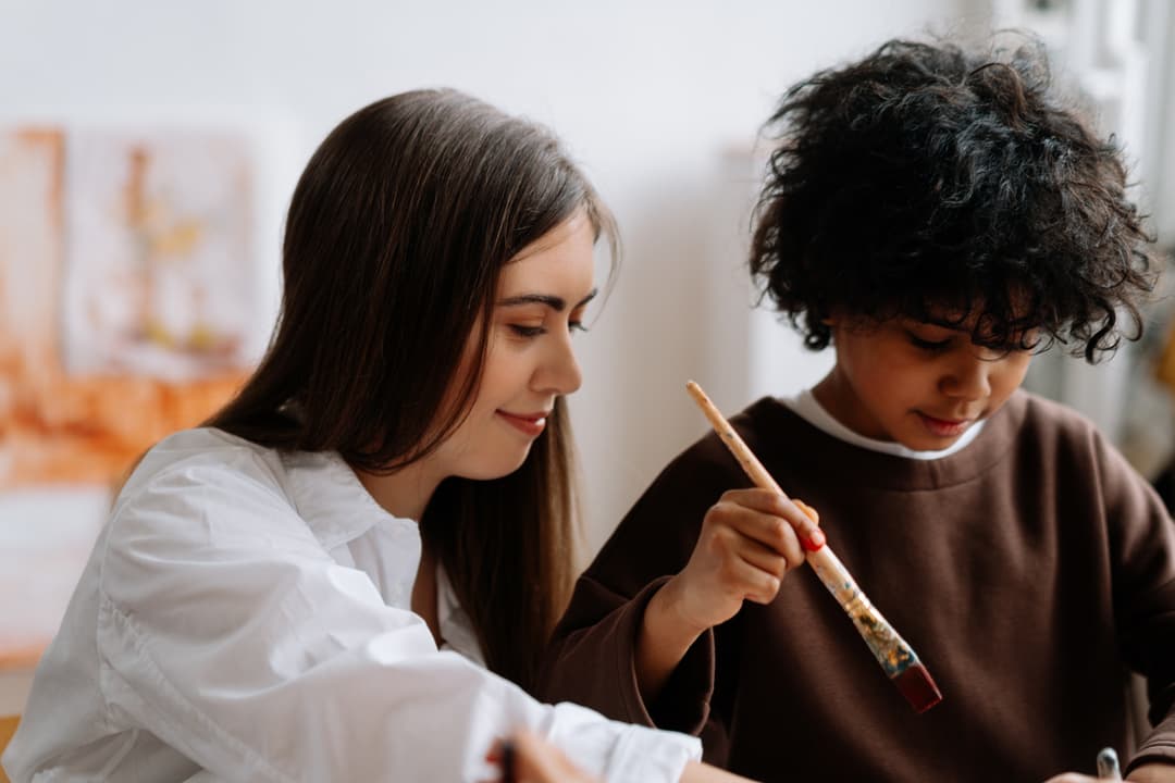 Teacher and young boy painting