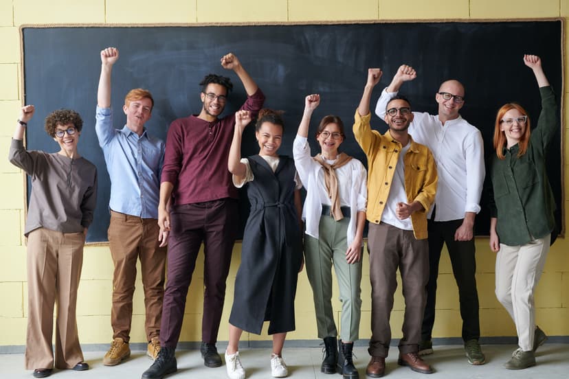 A group of people smiling holding their fists up in solidarity.
