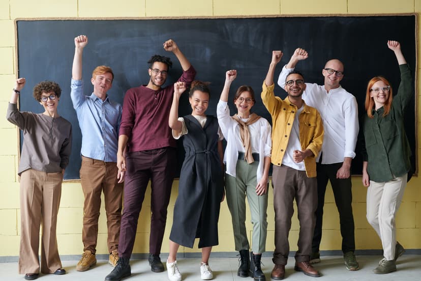 A group of people smiling holding their fists up in solidarity. 