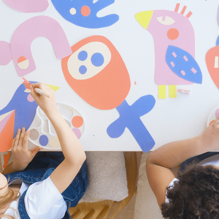 About us title picture. Two girls playing with colourful card.