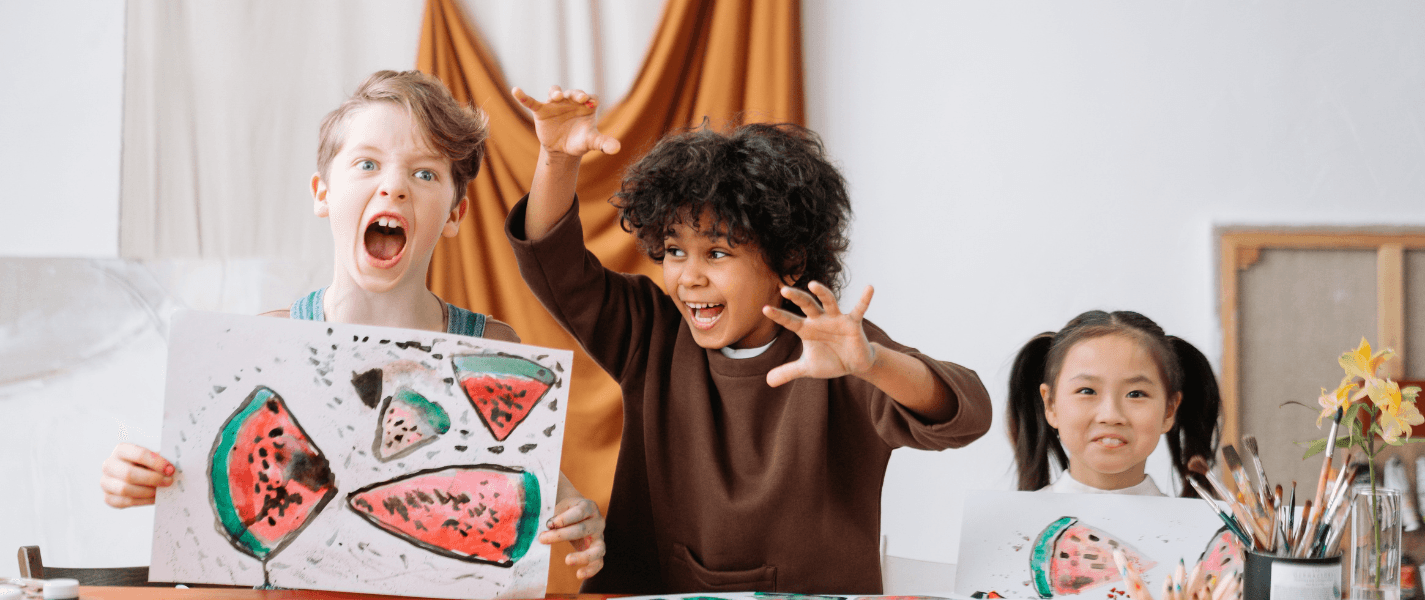 3 Kids showing their art work making silly faces and smiling